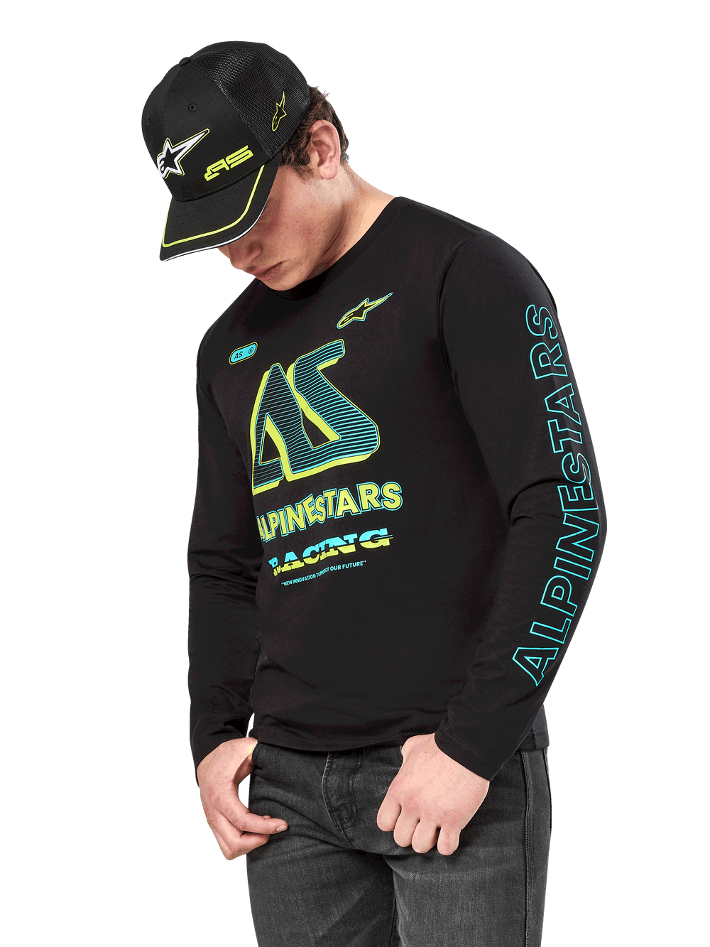 Alpinestars Ayess CSF Long Sleeve Tee, Black long sleeve shirt with neon yellow and cyan graphics, large AS chest logo and vertical Alpinestars branding on the sleeve, worn by a model with a matching black cap and dark jeans, casual motorsport lifestyle apparel