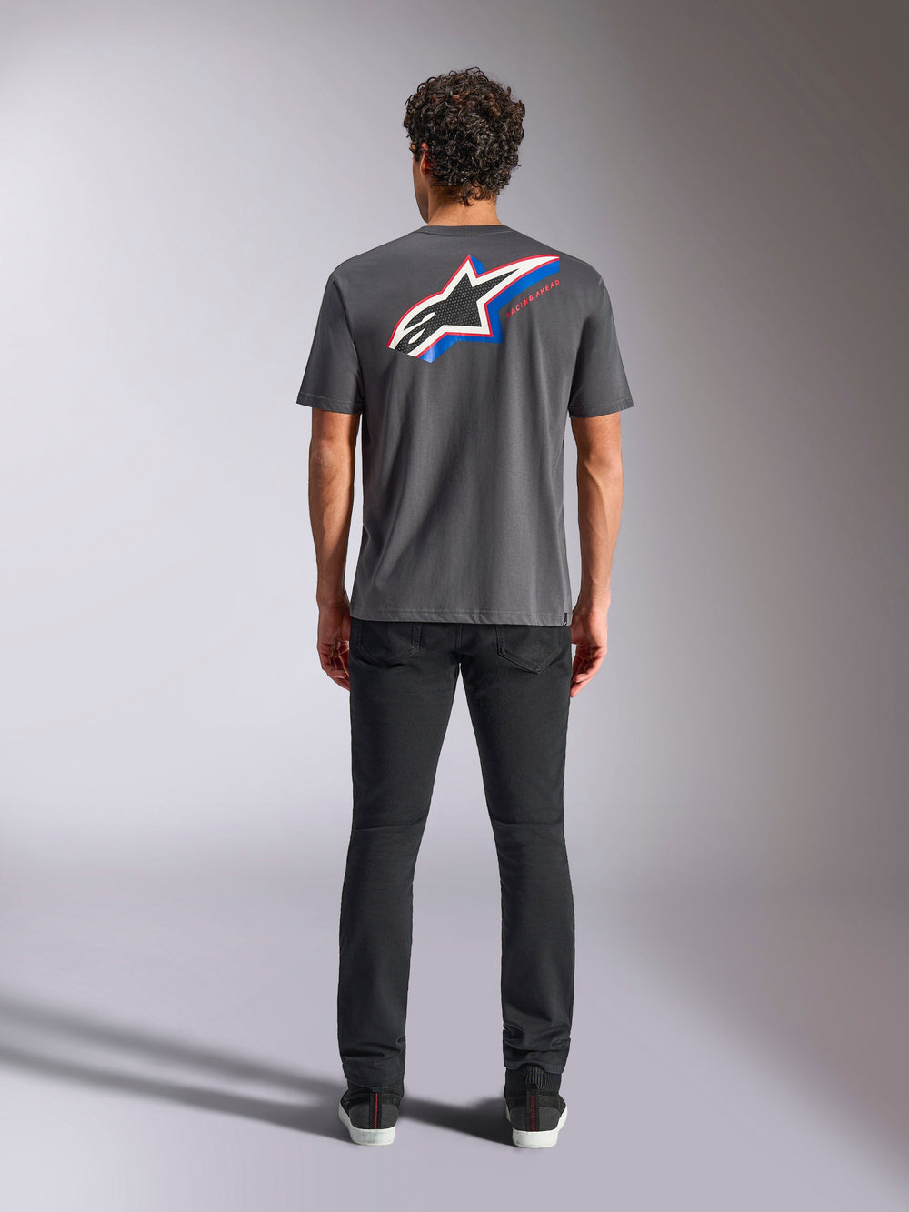 Alpinestars Angler CSF Tee, Short Sleeve T-Shirt, Charcoal, Large Multi-color Astars Logo on back with red and blue accents, rear view on model, casual motorsport streetwear