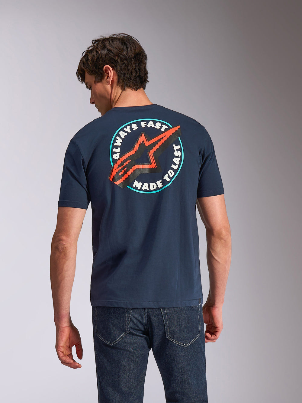 Alpinestars Aorbit CSF Tee, Short Sleeve T-Shirt, Navy Blue, back view on model featuring circular 'Always Fast Made to Last' graphic with red Astars logo, casual motorsport-inspired streetwear