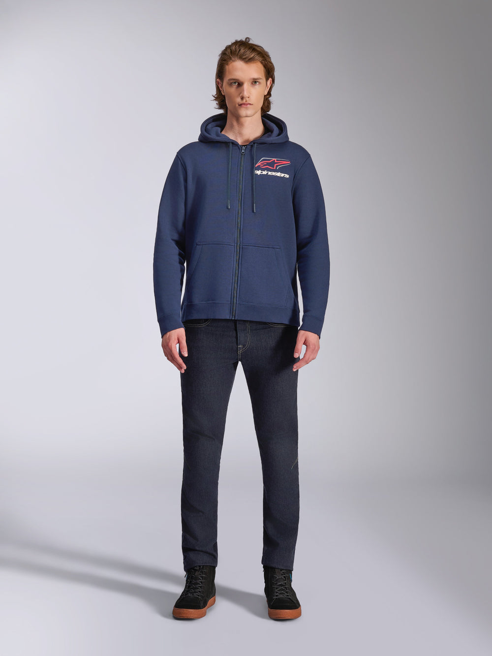 Alpinestars Formulation Hoodie, Navy Blue zip-up fleece hoodie, worn by male model with dark blue jeans, featuring red and white chest logo, mesh-lined hood with drawcords, casual motorsport streetwear
