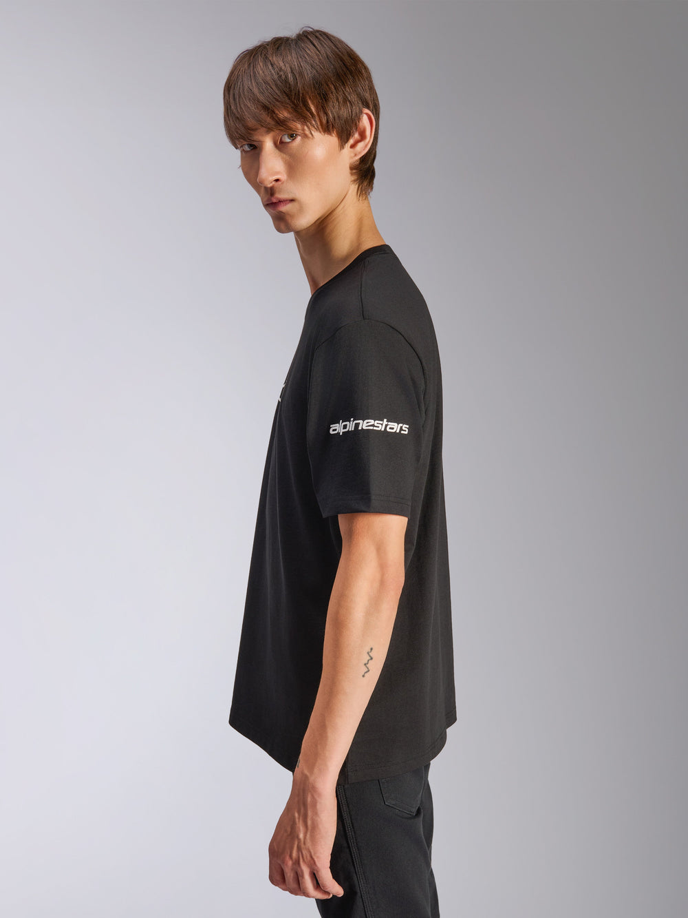 Alpinestars Frontal CSF Tee, Short Sleeve T-Shirt, Black, white Alpinestars logo on sleeve, worn by model in profile view, casual motorsport performance streetwear