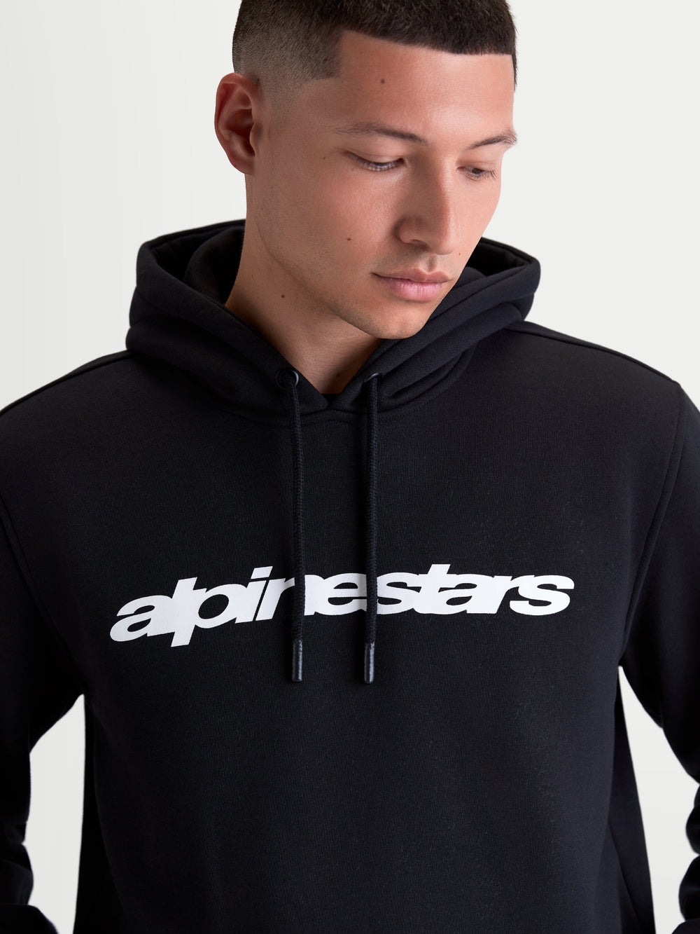 Alpinestars Race Wordmark Hoodie, Men's Casual Sportswear Pullover Fleece, Black and White, featuring a bold front linear logo, self-lined hood with dipped drawcord tips, constructed from a comfortable cotton and recycled polyester blend.