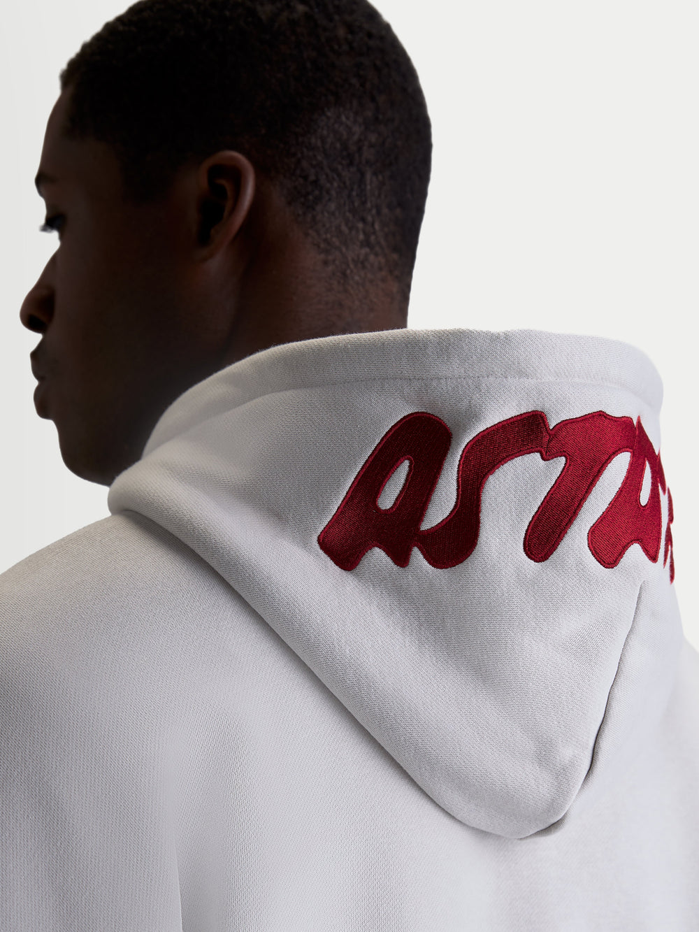 Alpinestars Pioneer Oversized Hoodie, Casual Sportswear Fleece for Men and Women, Cement Gray with Red embroidered logo on the hood, on-model back view highlighting the oversized fit and premium branding.