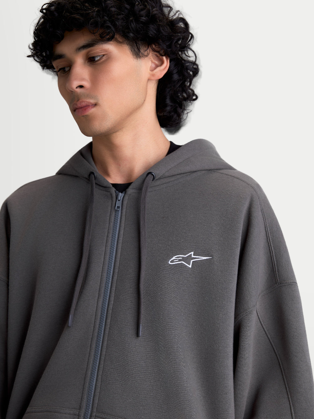 Alpinestars Entity Oversized Hoodie, Sportswear Zip Fleece for Men and Women, Charcoal Gray, 80% Cotton and 20% Recycled Polyester, featuring a Vislon front zipper, self-lined hood with flat drawcords, and a white Astars logo embroidered on the chest.