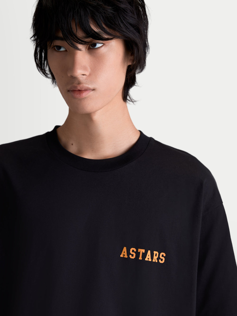 Alpinestars Latitude Oversized CSF Tee, Sportswear Lifestyle, Unisex, Black and Orange, Cotton-Poly Blend, On-model front view showing the soft-hand ASTARS wordmark graphic on the chest.