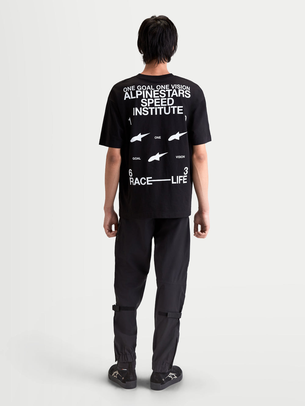 Alpinestars Institute Oversized CSF Tee, casual sportswear short sleeve t-shirt, black with white back logo graphics including 'Alpinestars Speed Institute' and 'One Goal One Vision', relaxed oversized fit, back view on-model.