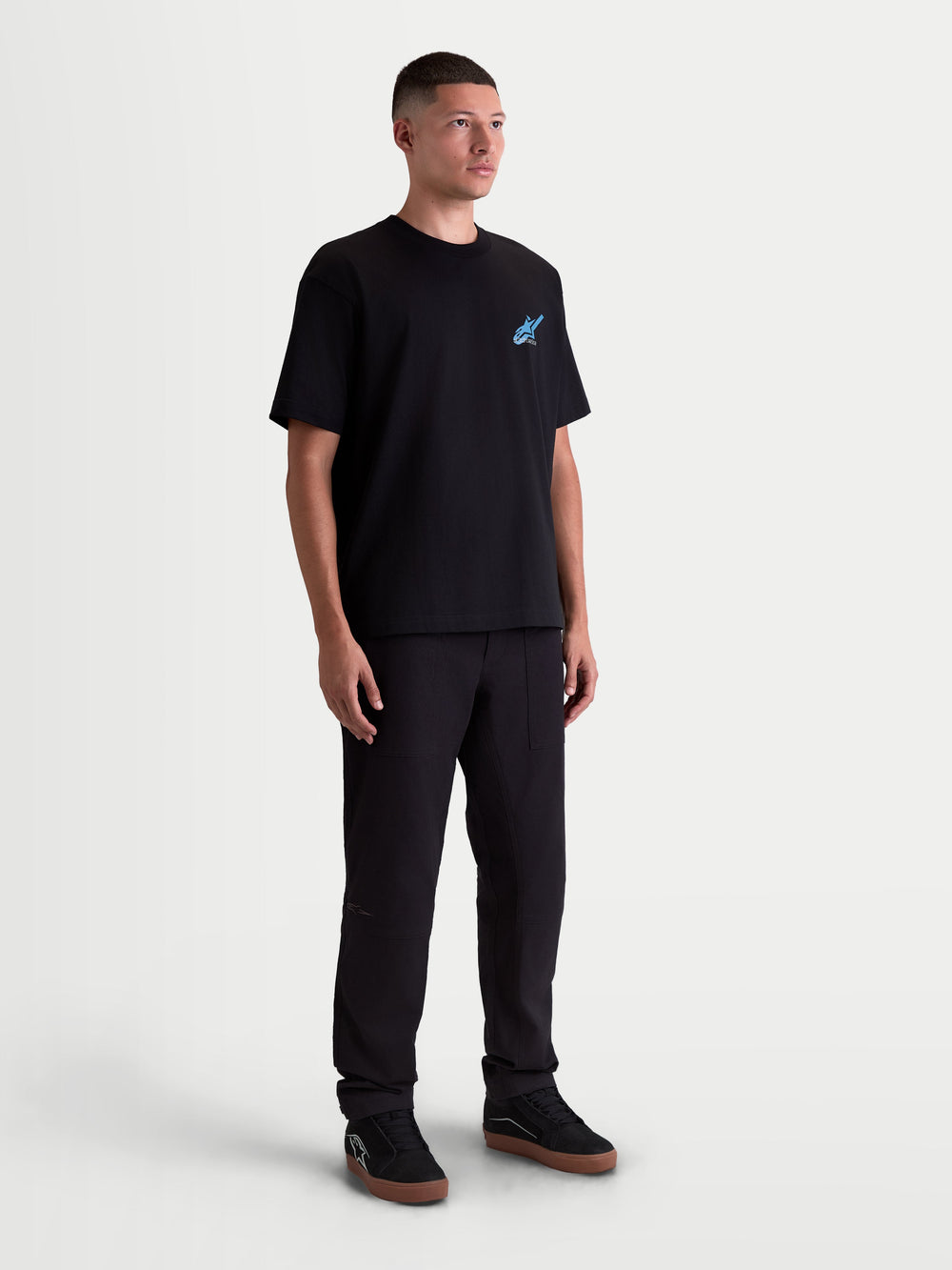 Alpinestars Ghost Oversized CSF Tee, Short Sleeve Sportswear T-Shirt, Unisex, Black with Blue Logo Graphic, premium cotton-poly blend, on-model full body view highlighting the relaxed oversized silhouette and motorsport-inspired aesthetic.