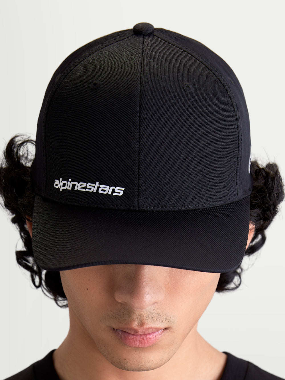 Alpinestars Points Hat, Black Curved Bill Sportswear Cap on Model, featuring White Alpinestars Word Logo on front, Lightweight Nylon Tactel Construction.
