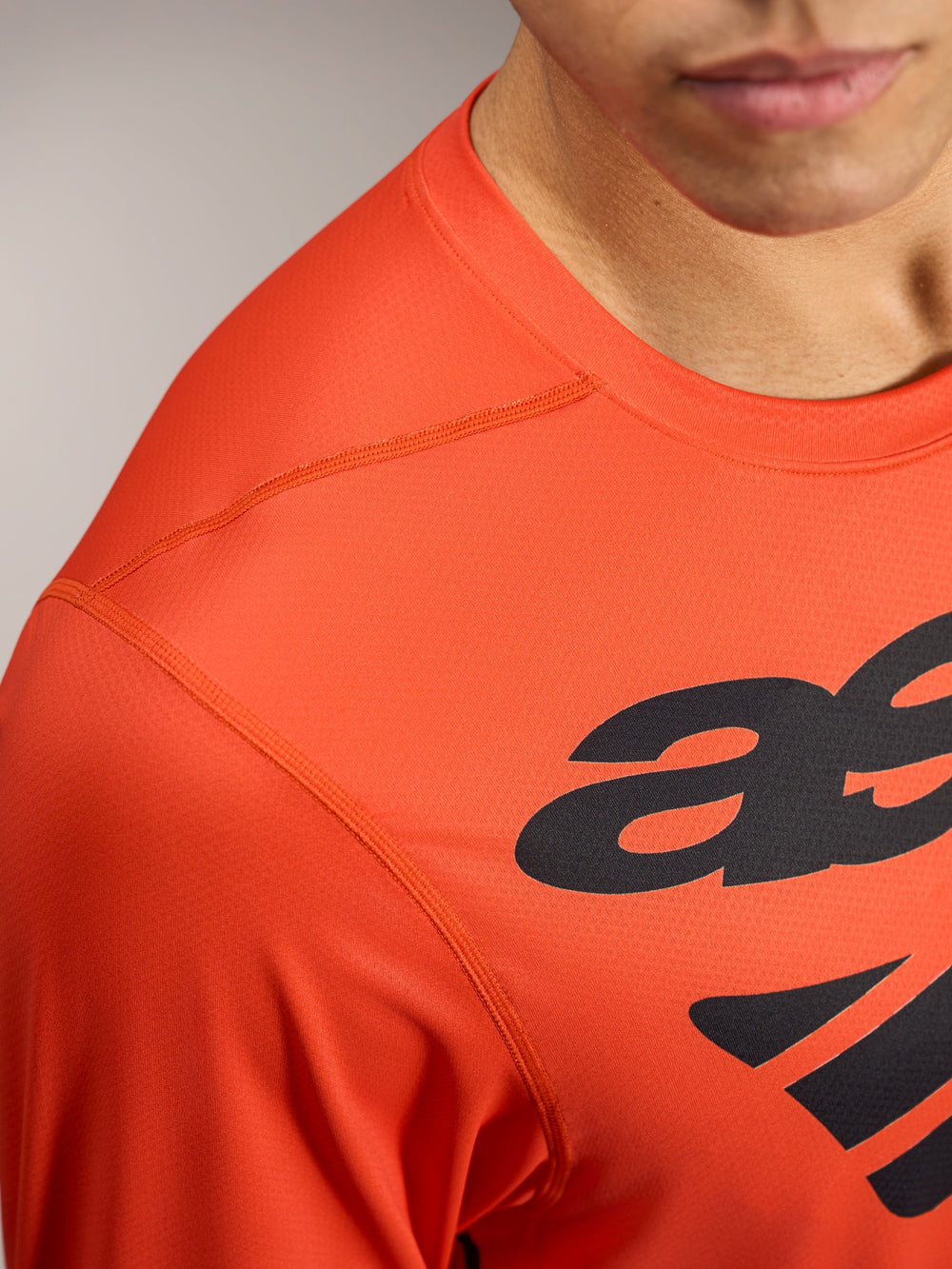 Orange A-Dura ASTARS Long Sleeve Jersey 2.0 featuring black logo graphics and breathable, textured performance fabric.