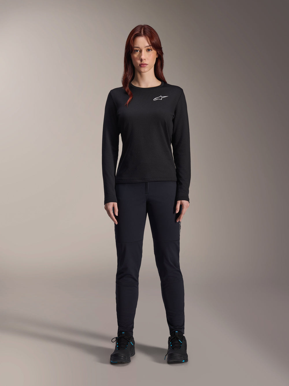 Alpinestars Stella A-Dura Thermal Jersey, Woman's Long-Sleeve Mountain Bike Jersey in Black, featuring a white chest logo, worn with matching black gear and cycling shoes, studio portrait.