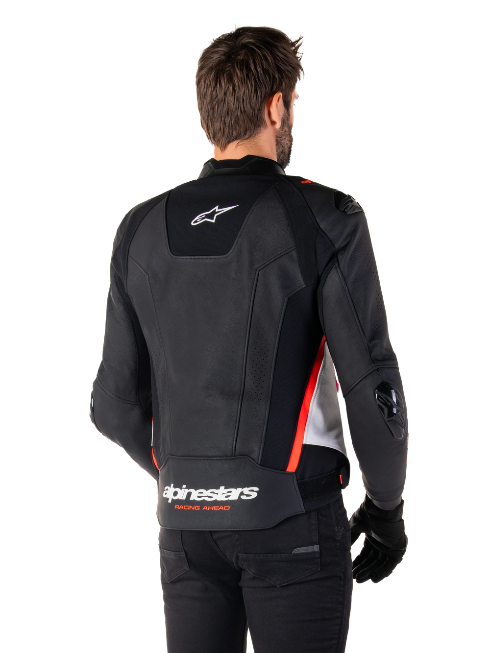 Alpinestars Missile V3 Leather Jacket, back view on a rider, Black White and Red Fluo, featuring bold Alpinestars branding and 'RACING AHEAD' text on the lower back, premium leather construction with technical stretch panels and protective TPU sliders, worn with black gloves and trousers.