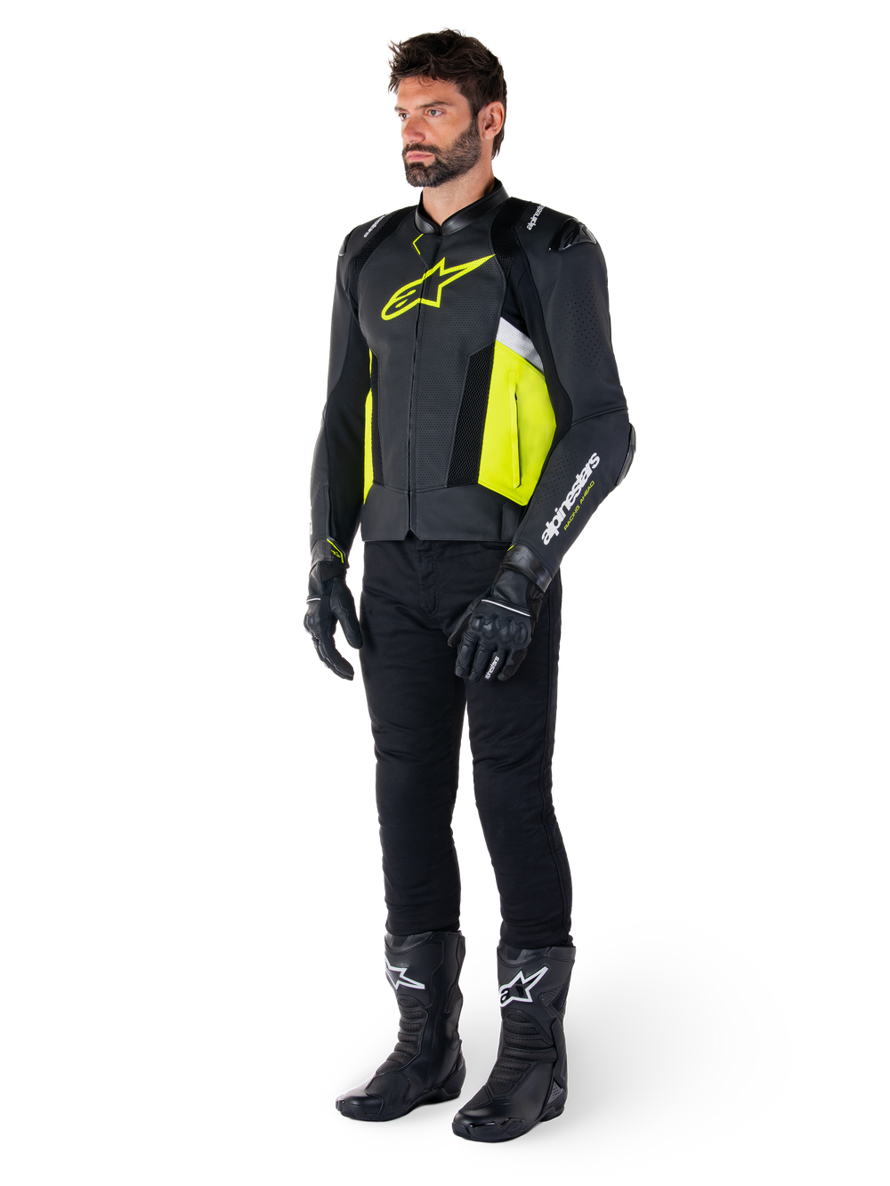 Male model wearing the Alpinestars Missile V3 Airflow Leather Jacket in Black, Yellow Fluo, and White, styled with black riding gloves, pants, and boots, showcasing the perforated leather design and racing-inspired aesthetic.