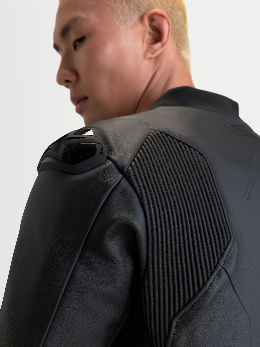 Alpinestars Caliber V2 Leather Jacket, Black, close-up view focusing on the shoulder armor and accordion mobility panels on a rider