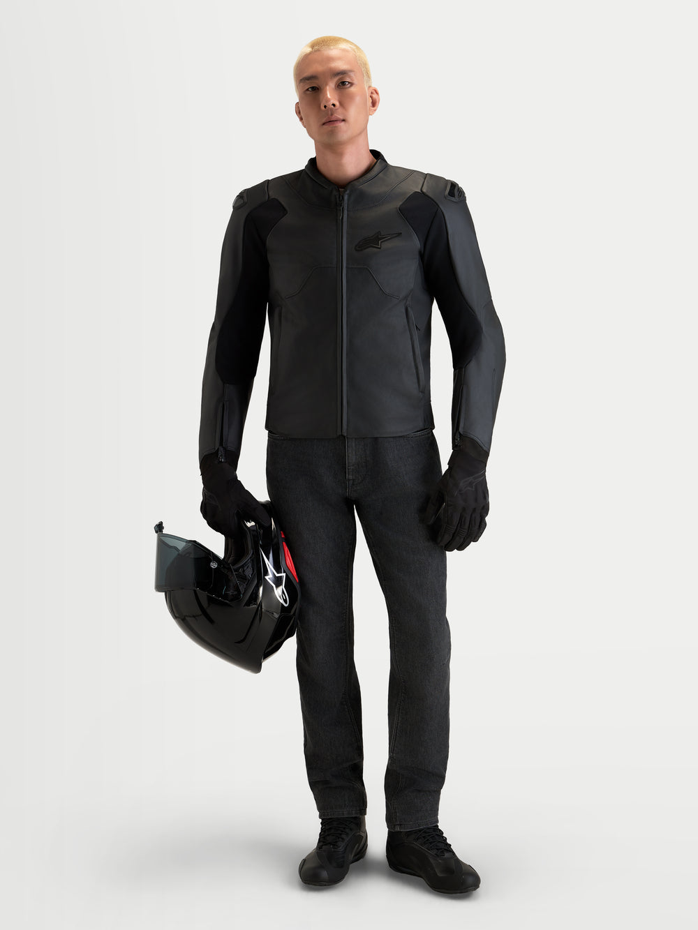 Alpinestars Caliber V2 Leather Jacket, Men's Black motorcycle leather jacket featuring AA-rated protection, low-profile DFS shoulders, and a full-grain bovine leather construction worn by a male model holding a black helmet