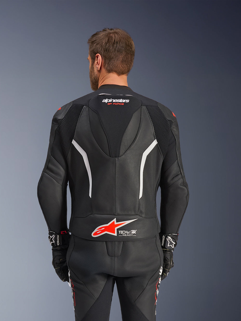 Alpinestars GP Force V2 Leather Suit - 2 Piece, Black White and Red Fluo, back view of leather jacket, featuring Tech-Air Ready logo, white accents, perforated leather panels, and accordion stretch for mobility.