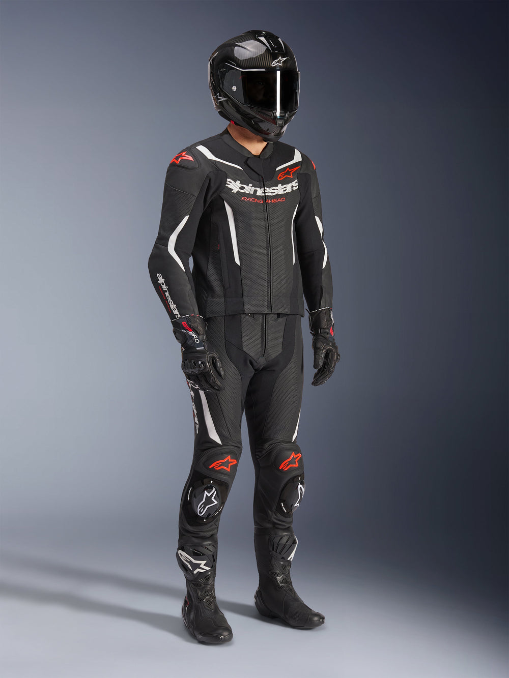 Alpinestars GP Force V2 2-Piece Leather Suit, Black White and Red Fluo, full body motorcycle racing gear featuring carbon fiber helmet, racing gloves, and boots, leather construction with perforated panels and aerodynamic speed hump.