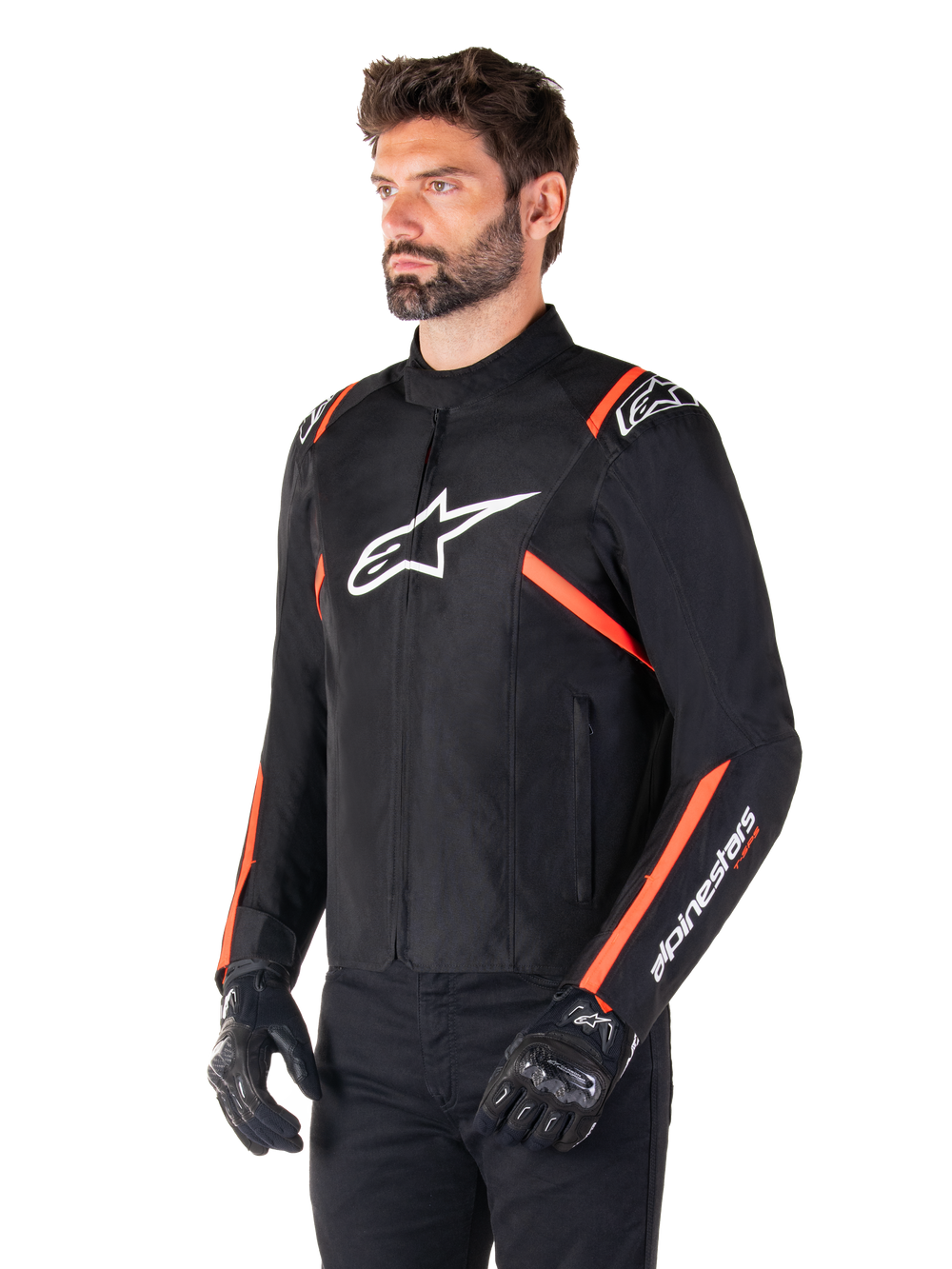 Alpinestars T-SPS V2 Waterproof Jacket, Black White and Red Fluo, worn by a male model with black gloves and pants, featuring a white Alpinestars logo on the chest and fluorescent red accents on the shoulders and sleeves, sporty textile design