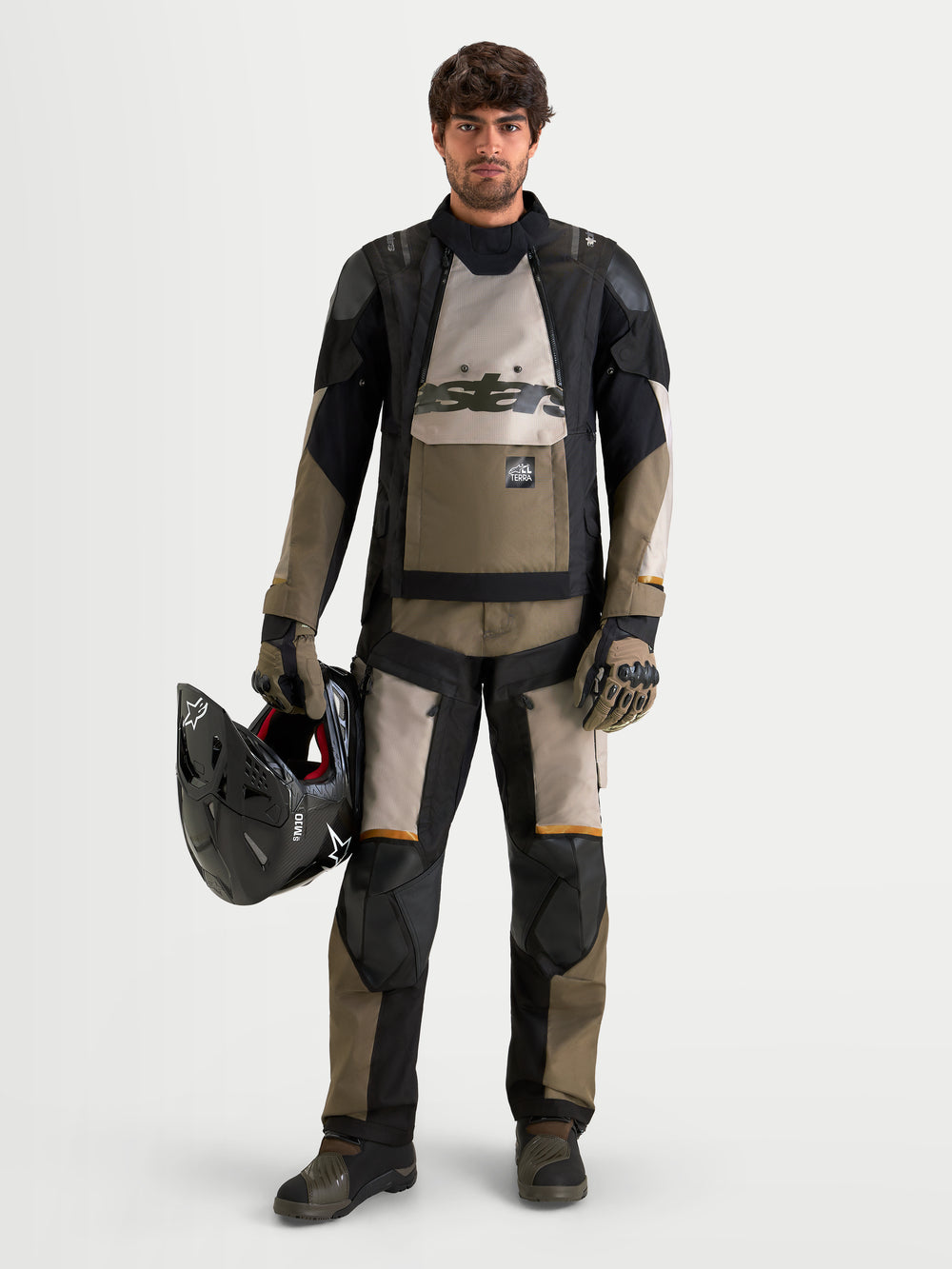 Alpinestars Harok V2 Drystar Jacket, men's all-terrain adventure motorcycle jacket in aluminum, walnut, and black, worn with matching adventure gear while holding a helmet