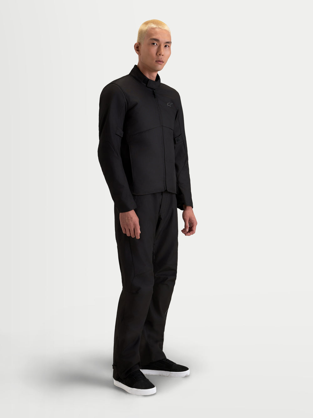 Alpinestars C-1 Waterproof Jacket, men's urban contemporary motorcycle textile jacket in black, side view on a model wearing matching trousers, featuring waterproof polyfabric construction and soft-finish collar.