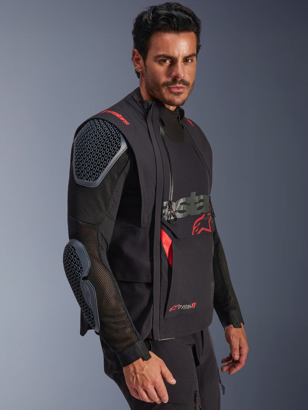 Alpinestars Halo Pro Drystar® XF Laminated Jacket, Black and Dark Shadow, adventure motorcycle jacket worn by model, modular configuration featuring mesh sleeves with integrated shoulder and elbow armor, red logo accents and technical waterproof zippers.