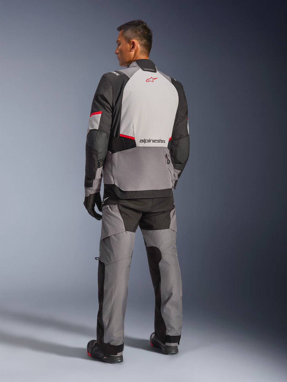 Alpinestars Andes V4 Drystar® Jacket, Dark Gray and Ice Gray with Black and Bright Red accents, back view showing light gray panel with red star logo, paired with matching adventure pants and black gloves, technical all-weather motorcycle gear.