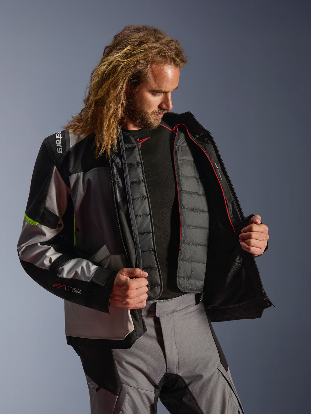 Alpinestars Andes V4 Drystar® Jacket, adventure motorcycle gear in Dark Gray, Ice Gray, and Yellow Fluo, male model displaying the internal quilted thermal liner, worn with matching riding pants, all-weather performance design