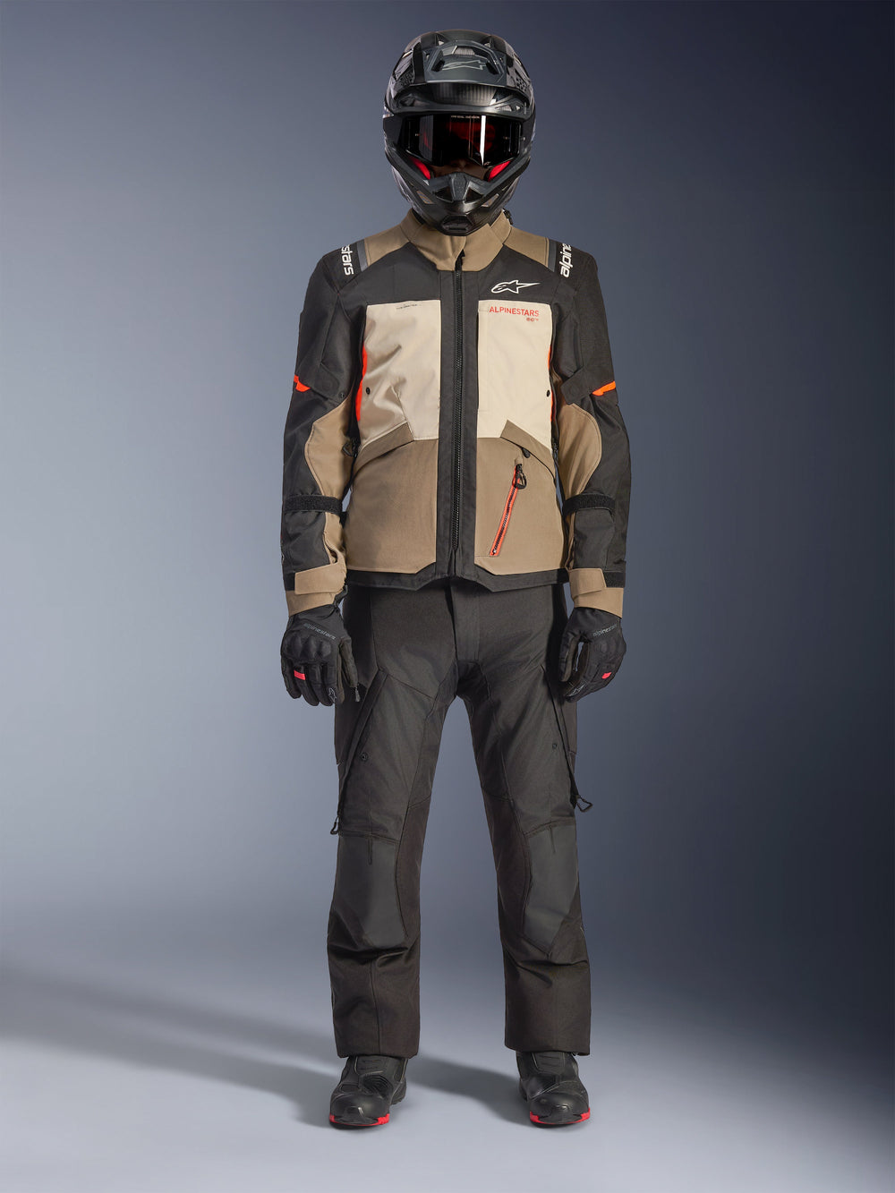 Alpinestars Andes V4 Drystar® Jacket, Walnut Mastic Black, adventure touring motorcycle jacket with tan and cream panels and orange accents, worn by a rider with a black adventure helmet, black riding pants, and black boots, full-body studio view