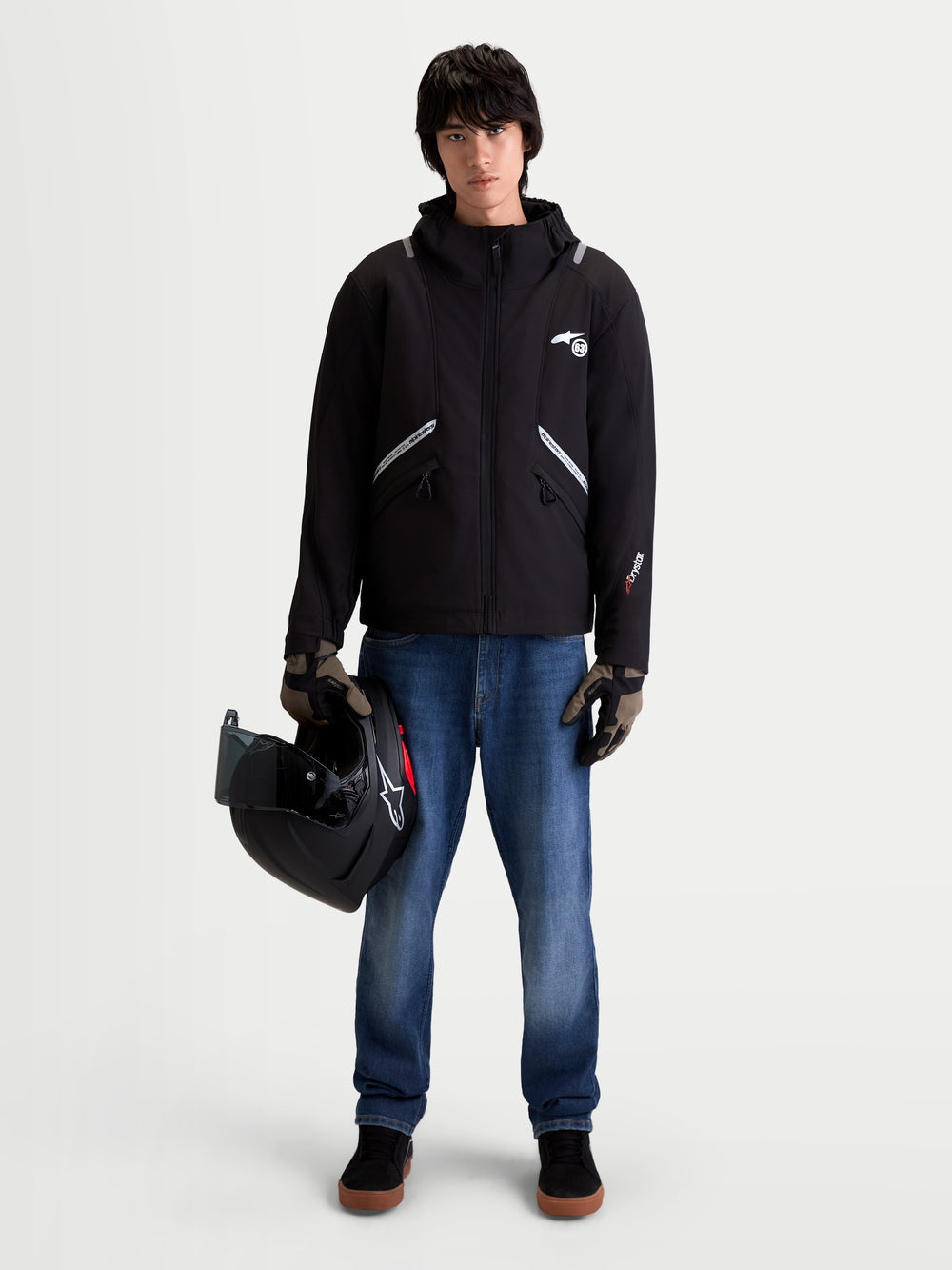 Alpinestars C-5 Drystar Jacket, men's urban contemporary motorcycle textile jacket in black, front view on a model wearing jeans, gloves, and holding a helmet, showcasing waterproof softshell construction and integrated hood.