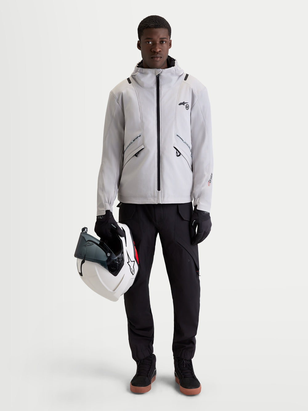 Alpinestars C-5 Drystar Jacket, men's urban contemporary motorcycle textile jacket in light gray and black, front view of a model wearing the waterproof jacket, integrated hood, and holding a helmet