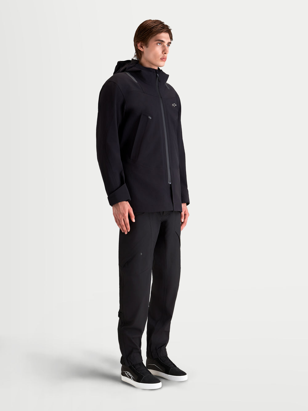 Alpinestars C-7 Drystar®XF Jacket, men's urban contemporary motorcycle textile jacket in black, side profile view worn by a model featuring waterproof laminated construction and integrated hood
