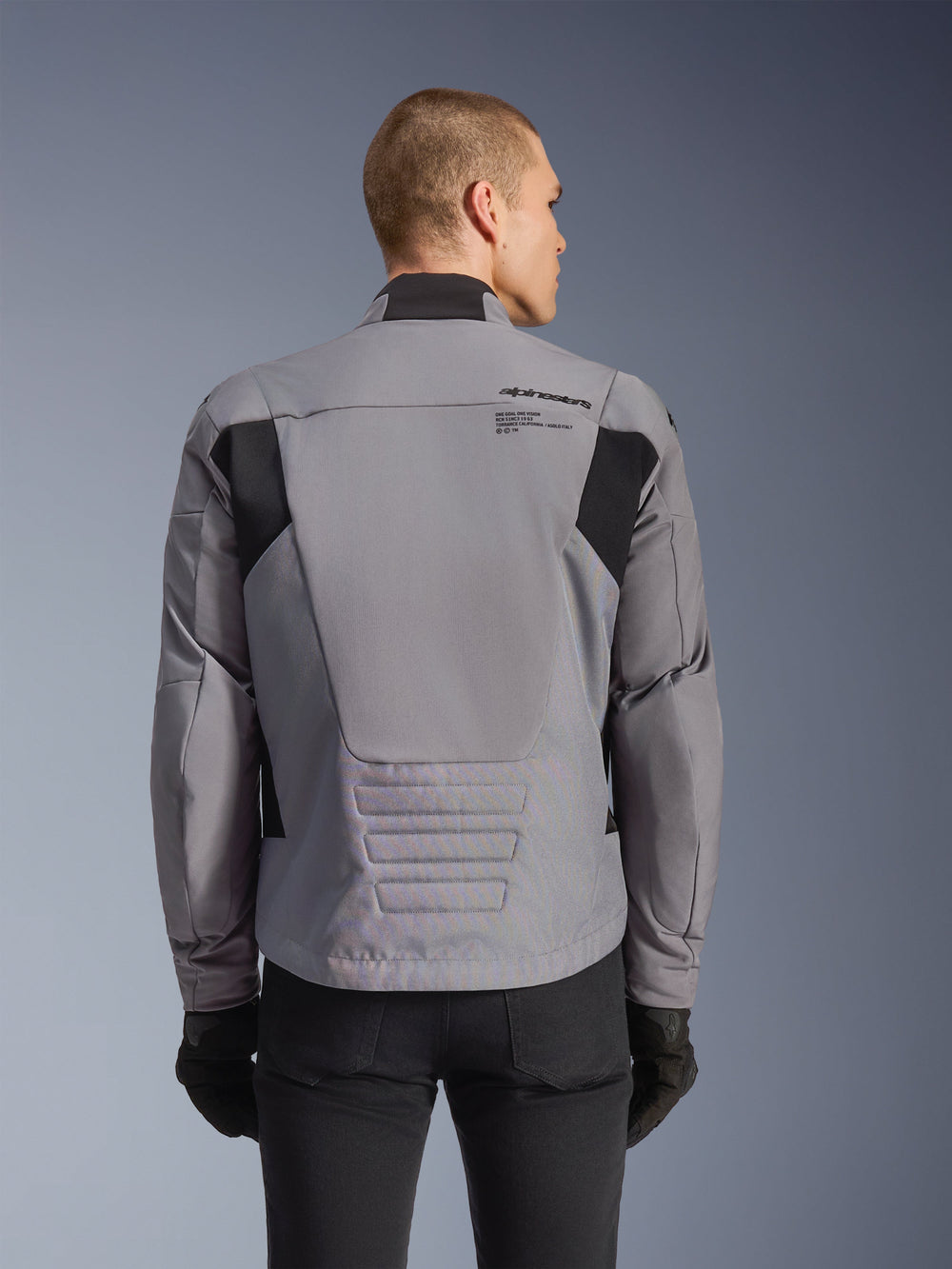 Alpinestars SMX Waterproof Jacket, Gray with black accents, back view showing upper back branding and elongated rear profile, worn by a model with black pants and gloves