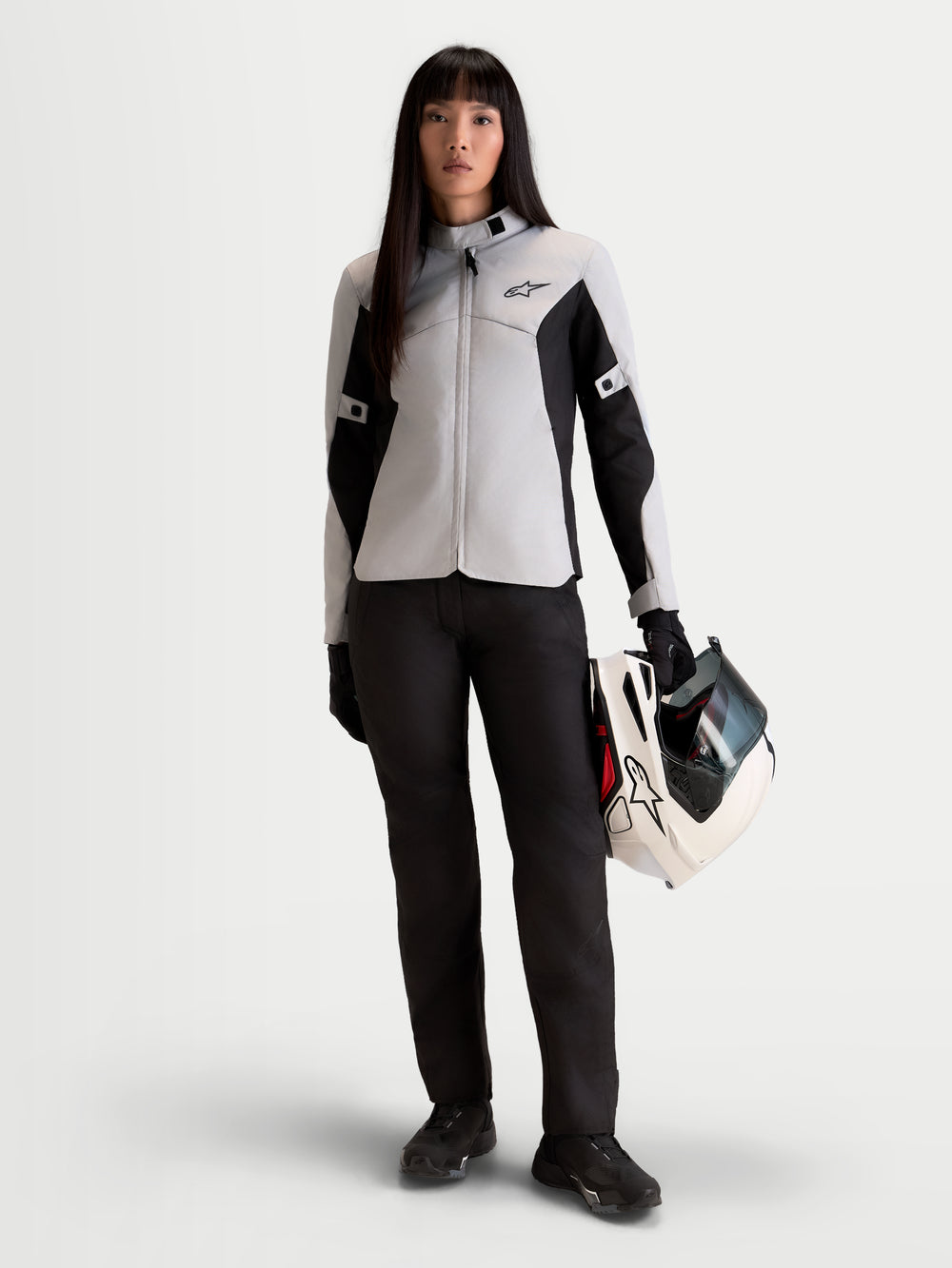 Alpinestars Stella C-1 Waterproof Jacket, women's urban motorcycle jacket in ice gray and black, front view worn by a model holding a matching helmet, textile commuter riding apparel.
