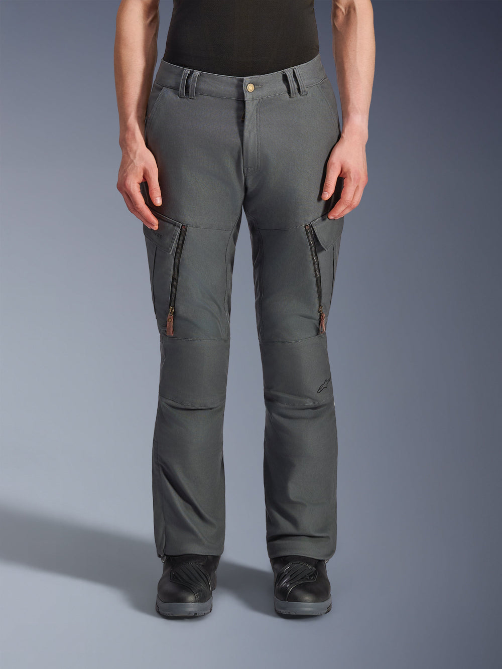 Alpinestars Borrego Drystar® Pants, Adventure Motorcycle Pants, Anthracite Gray, featuring vertical thigh zipper pockets with leather pull tabs, button waist closure, and belt loops, worn by a model with black motorcycle boots