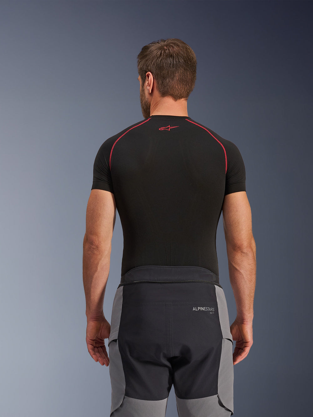 Alpinestars Andes Pro Drystar® XF Pants, Adventure Motorcycle Pants, Dark Gray and Black, rear view showing waist construction and gray side panels, worn with a black base layer top featuring red stitching, technical all-weather touring gear.