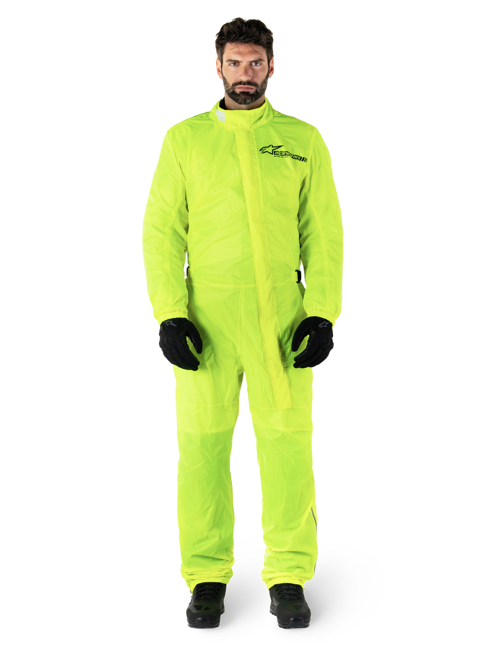 Alpinestars Hurricane Rain V2 Suit, Motorcycle Rain Suit, Yellow Fluo, male model wearing full-body protection with black gloves and boots, high collar with front storm flap, reflective logo on chest, high-visibility waterproof gear