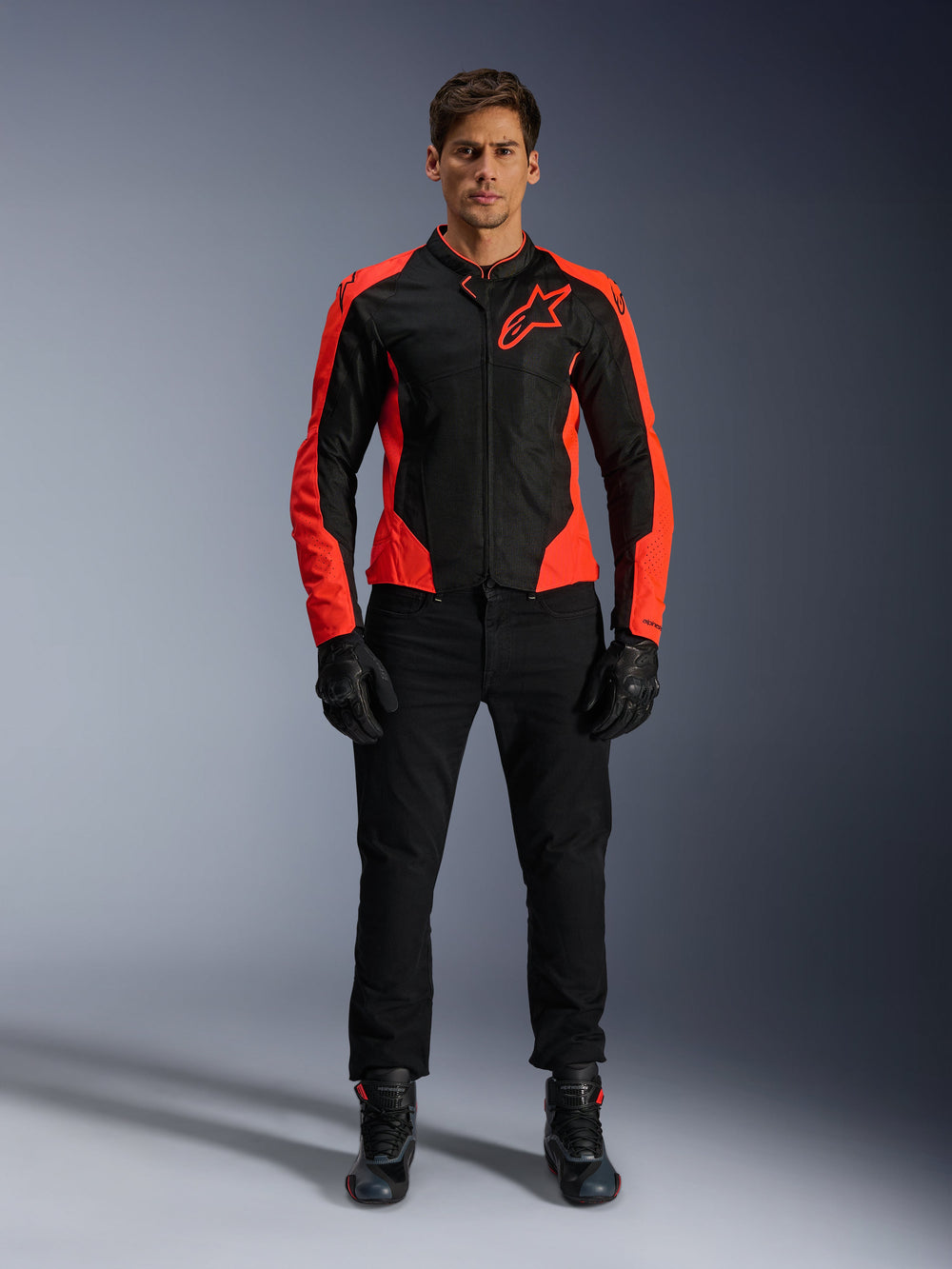 Male model wearing the Alpinestars Viper Air V4 Jacket in Red Fluo and Black, paired with black riding pants, gloves, and boots, featuring breathable mesh panels for ventilation and a bold star logo on the chest, sporty motorcycle road apparel