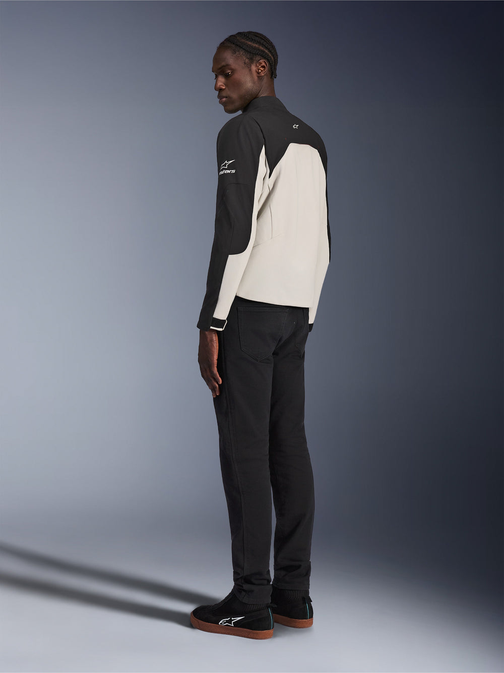 Alpinestars Provoke Jacket, urban motorcycle jacket, Black and Metal Gray, rear three-quarter view on a model, two-tone textile construction with Alpinestars logo on the shoulder, worn with black pants and black sneakers, contemporary street-ready protection