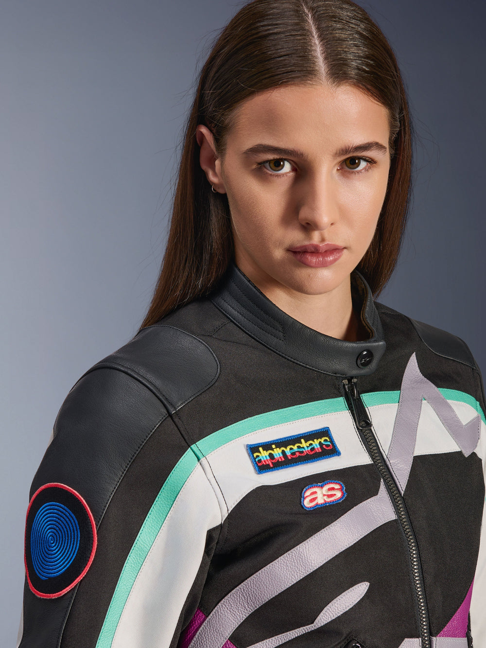 Alpinestars Idles Women's Jacket, Motorcycle Jacket, Black Off White and Purple with teal accents, close-up featuring colorful Alpinestars heritage patches and goat leather shoulder details, vintage-inspired design for urban riding.