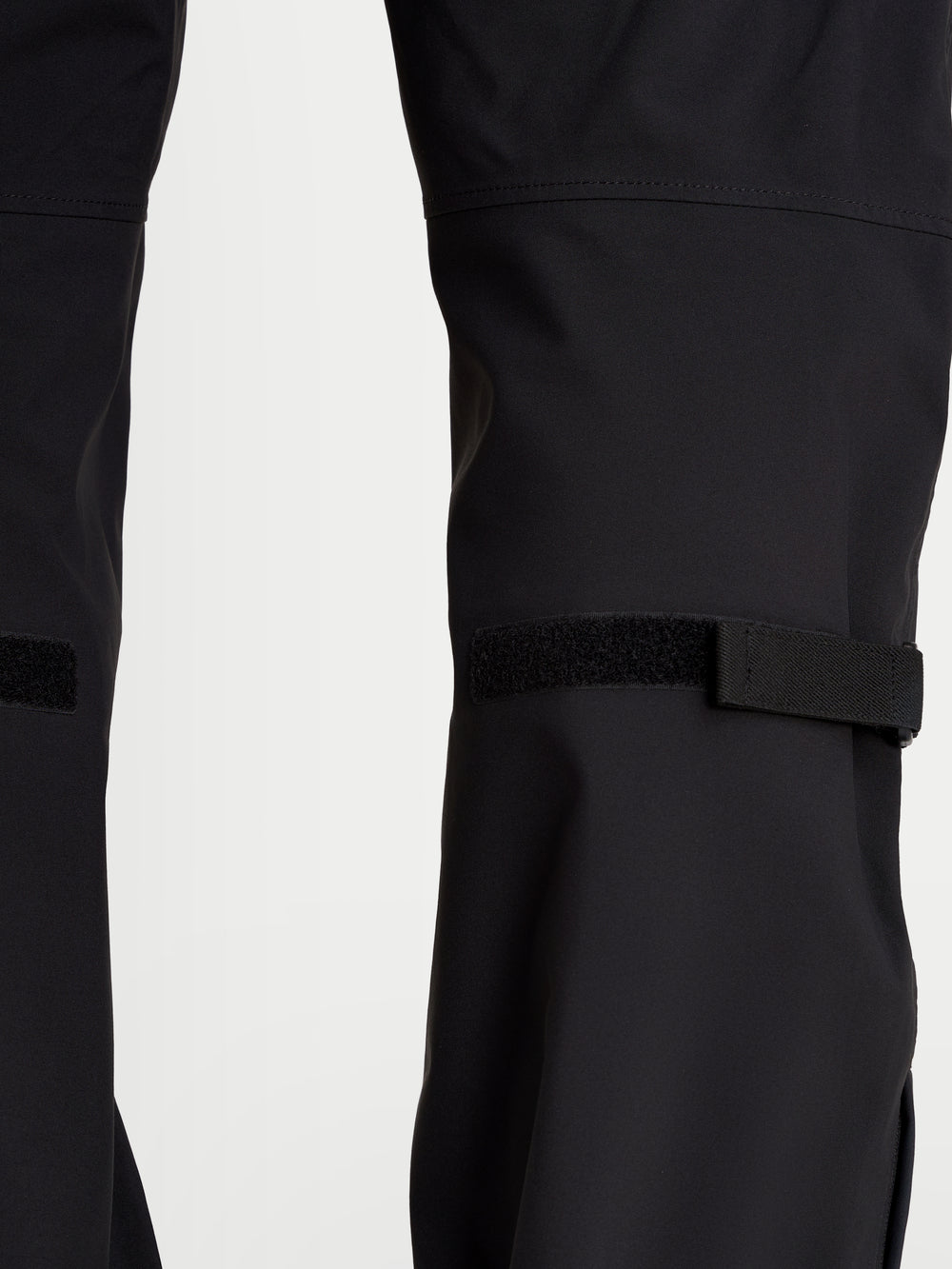 Alpinestars Juggernaut V2 Drystar Pants, men's urban waterproof motorcycle pants in black, close-up view showing lower leg adjusters and technical textile construction