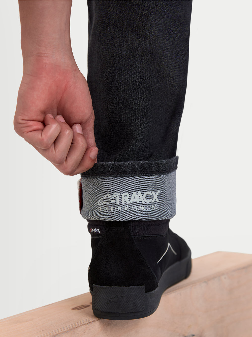 Alpinestars Flex-AST 8 Denim Pants Short, urban motorcycle riding jeans, used black, detailed view showing rolled cuff with A-TRAACX tech denim monolayer branding and footwear