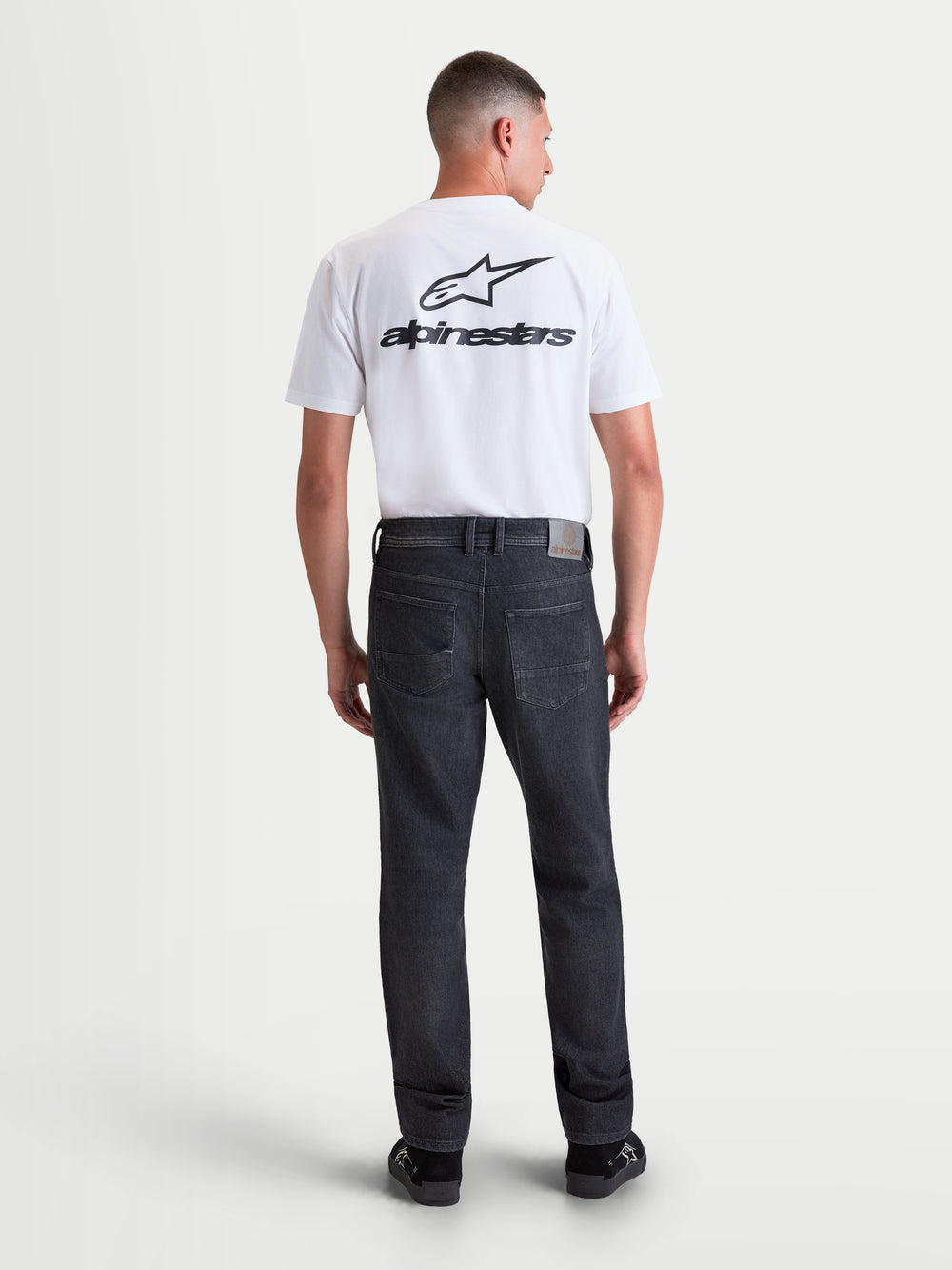 Alpinestars Flex-AST 8 Denim Pants Short, men's urban motorcycle riding jeans in used black, rear view showing single-layer technical denim construction, five-pocket layout, and straight-leg fit worn by a model.