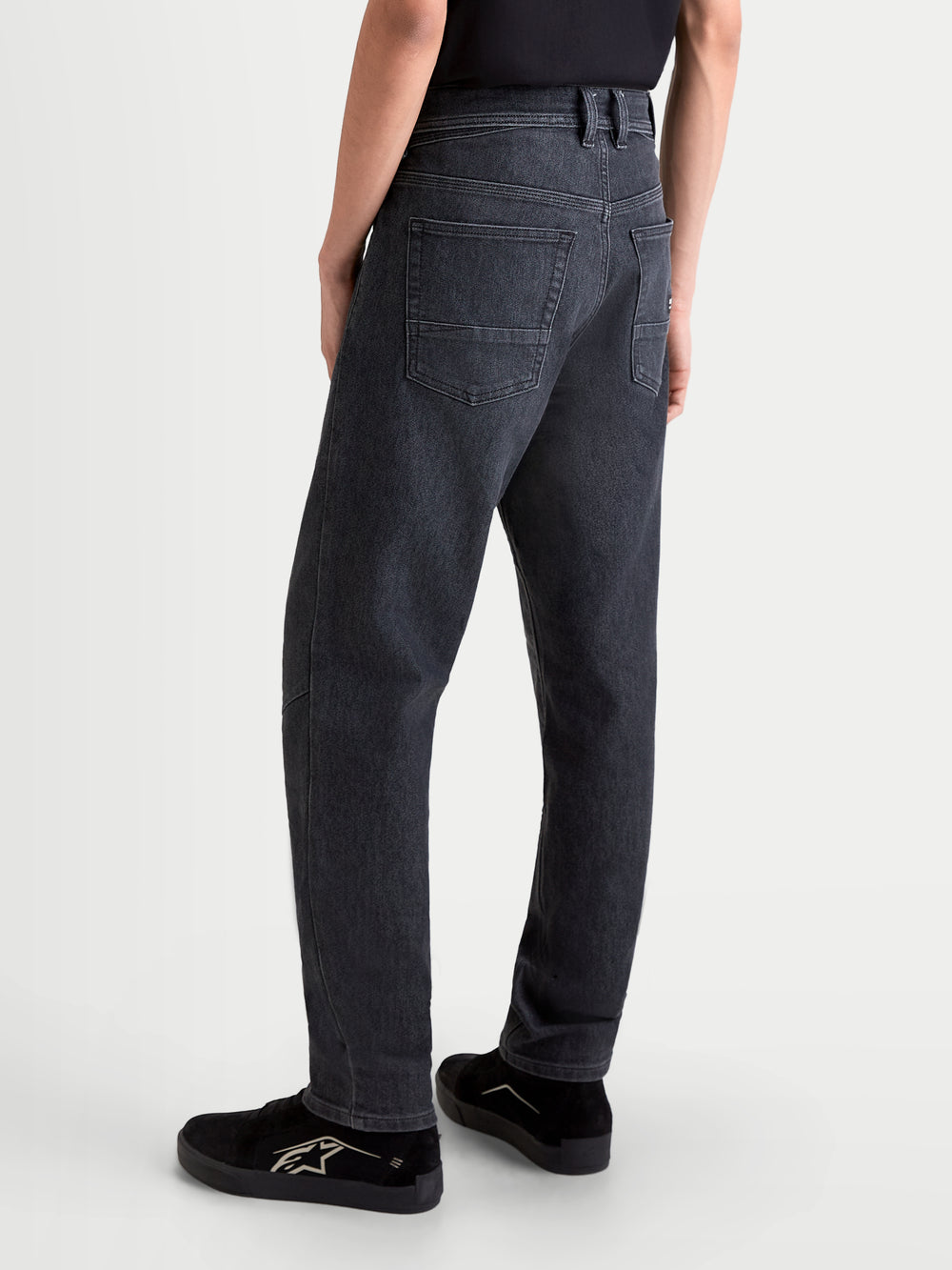 Alpinestars Flex-AST 7 Denim Pants, men's urban motorcycle riding jeans in faded black, rear view showing single-layer technical denim construction, five-pocket layout, and comfortable regular cut worn by a model.