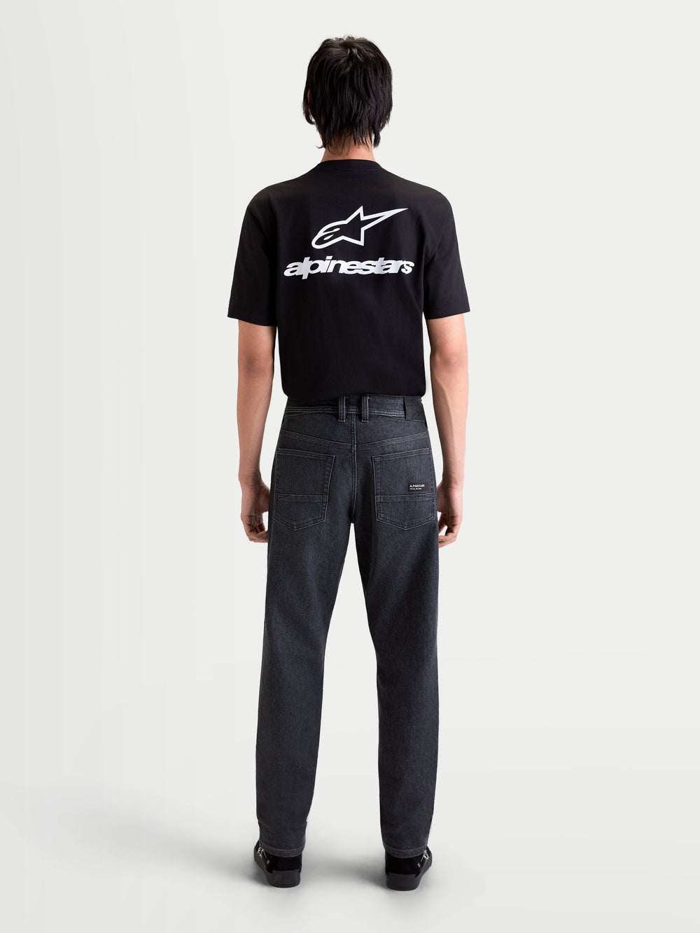 Alpinestars Flex-AST 7 Denim Pants Short, men's urban motorcycle denim pants in faded black, rear view on a model wearing a black t-shirt, showing single-layer technical denim construction and regular tapered fit