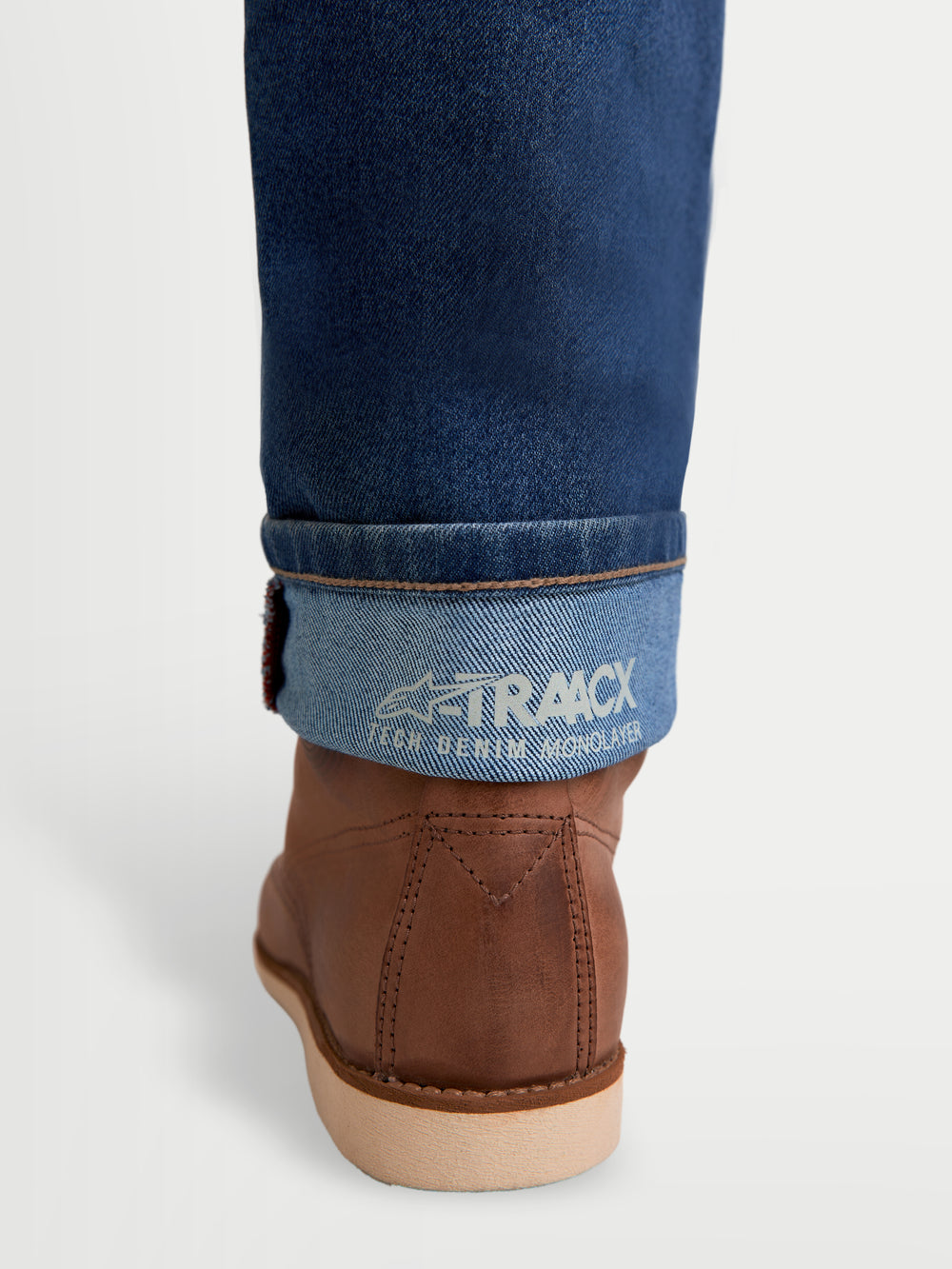 Alpinestars Flex-AST 7 Denim Pants Short, urban motorcycle riding jeans cuff detail, light blue denim with selvedge finish and A-TRAACX technical branding, worn with brown boots