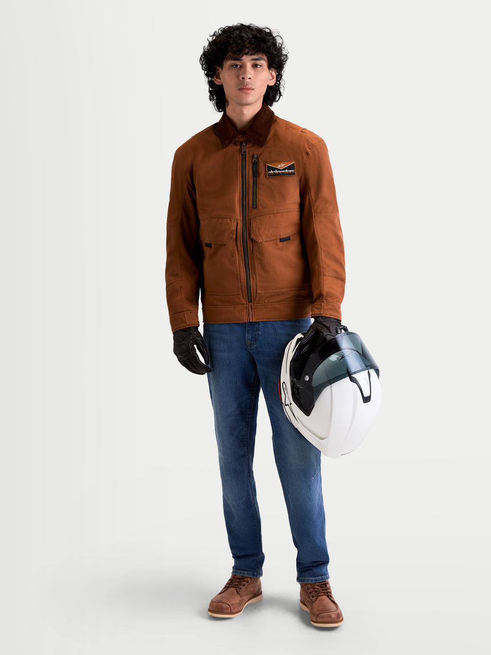 Alpinestars Flex-AST 7 Denim Pants Short, men's urban contemporary motorcycle riding jeans in light blue, worn by a model holding a helmet and wearing a brown jacket, AA certified technical denim