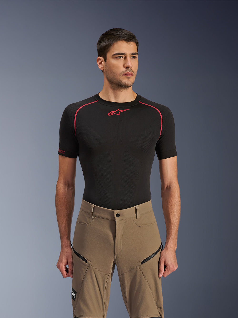Alpinestars Flex-AST Explorer Pants, Adventure Motorcycle Pants, Walnut Black, worn by a model with a black base layer shirt, featuring diagonal zippered cargo pockets and durable stretch textile construction.