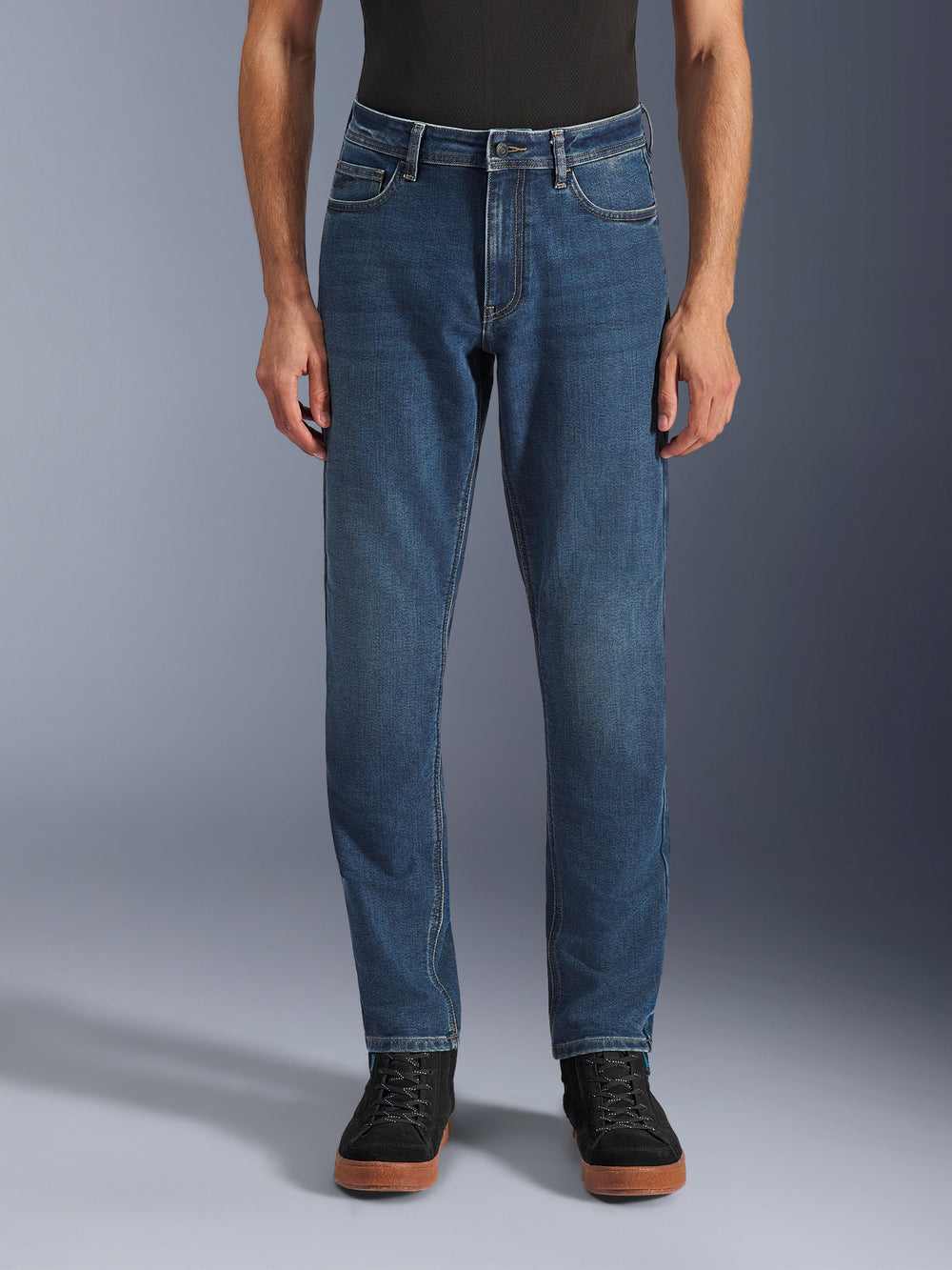 Alpinestars Flex-AST 5 Denim Pants, Urban Motorcycle Jeans, Indigo Washed Blue, front view showing a modern tapered fit and casual five-pocket styling, worn with a black top and sneakers, designed for urban riding comfort and protection.