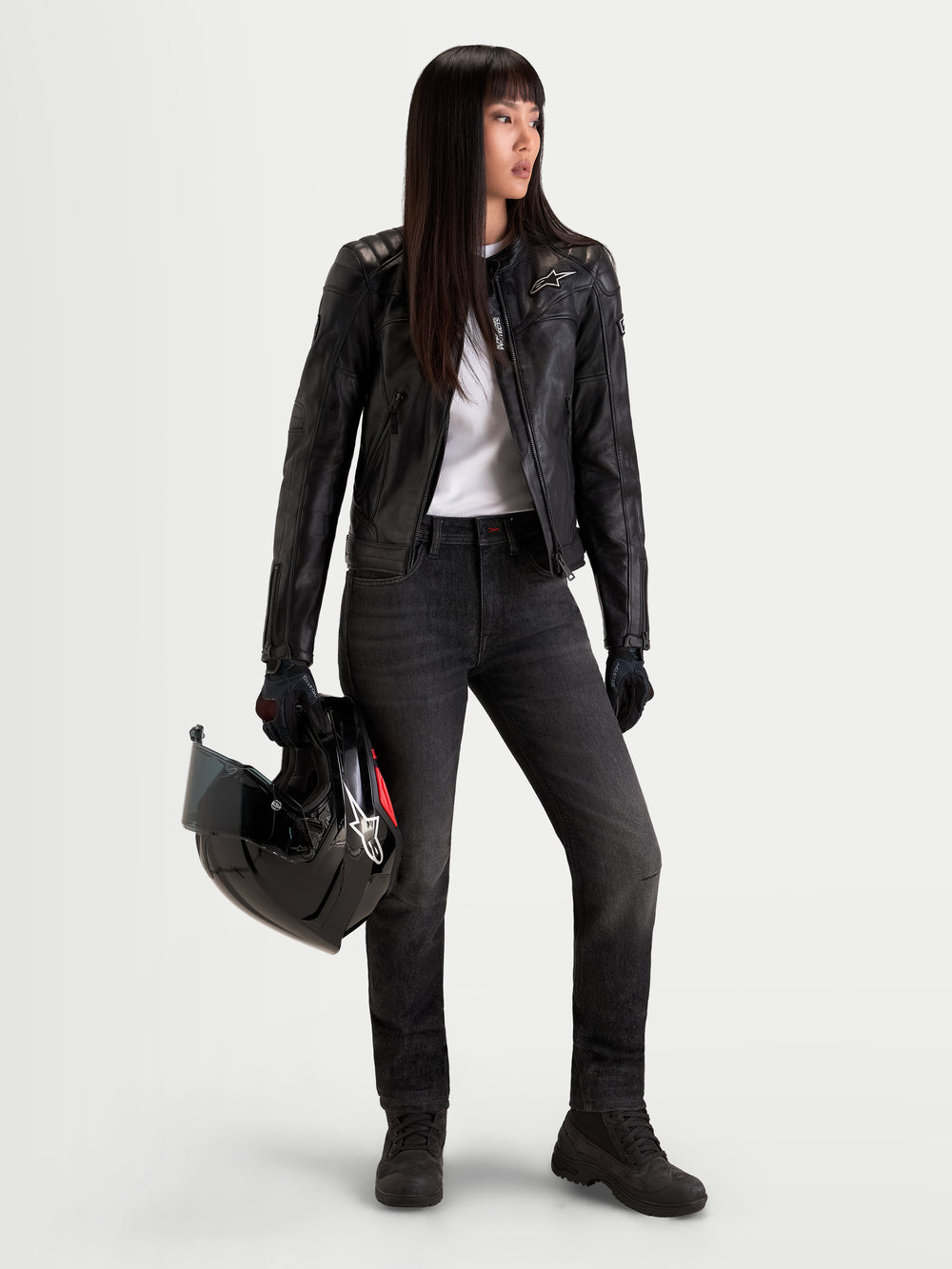 Alpinestars Stella Flex-AST 7 Denim Pants, women's urban contemporary motorcycle riding pants, faded black, single-layer AA-rated technical denim with COOLMAX comfort, worn by a model holding a helmet and matching leather jacket