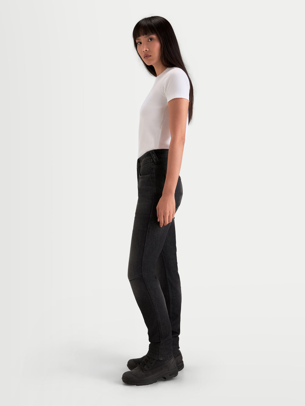 Alpinestars Stella Flex-AST 7 Denim Pants, women's urban contemporary motorcycle pants in faded black, side profile view on a model wearing protective riding denim and matching boots