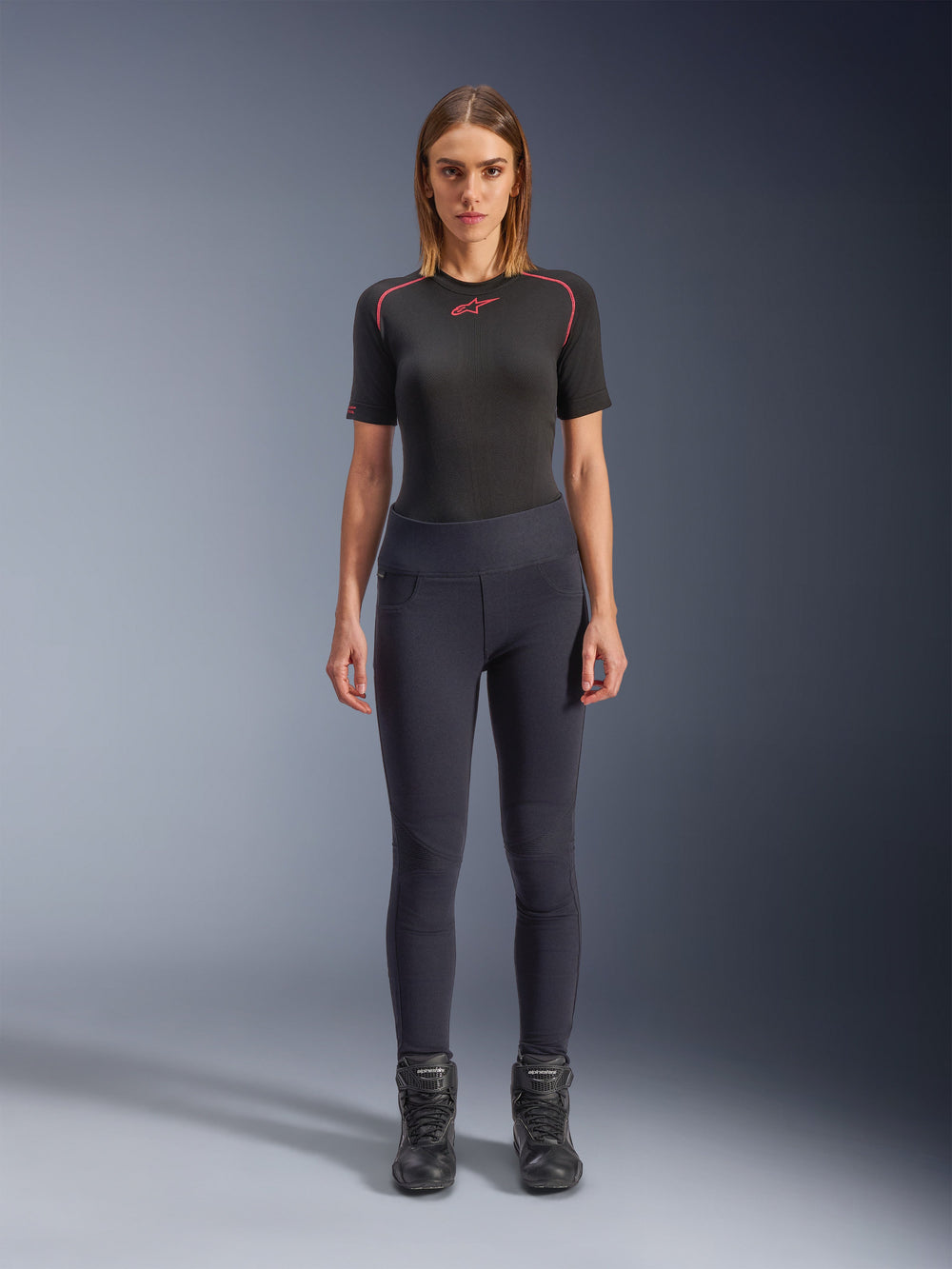 Alpinestars Stella Flex-Ast Leggings, Woman's Motorcycle Leggings, Black, worn with a black short-sleeved top with red details and black riding boots, slim-fit contemporary urban riding gear, front view